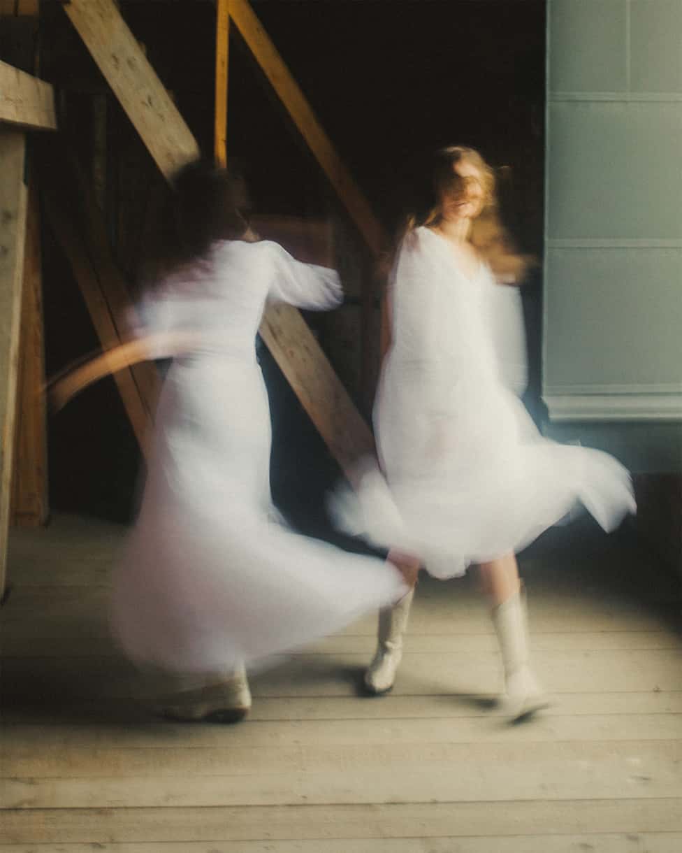 Band members dancing in white dresses